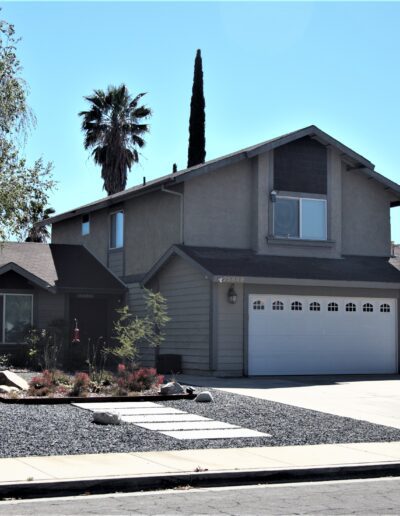 A two-story suburban house with a double garage and landscaped front yard.