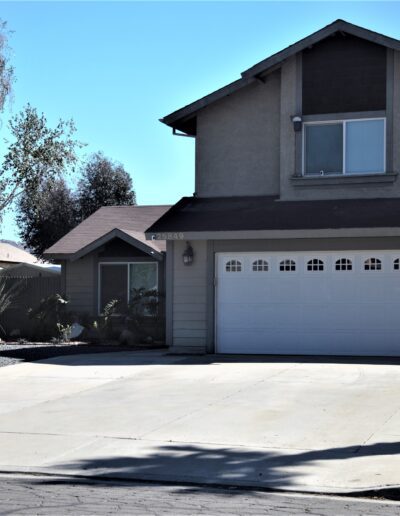 A two-story suburban house with a garage and a landscaped front yard.