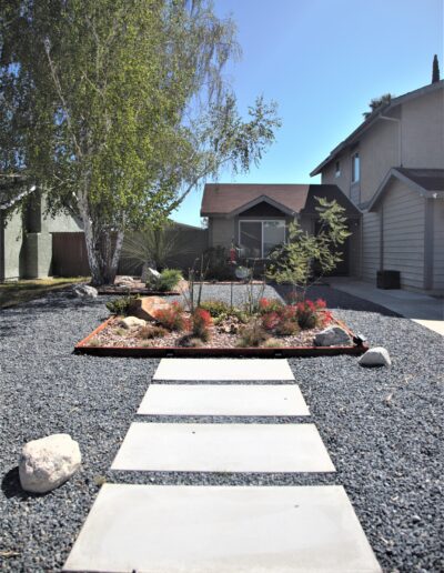 Modern home with xeriscaped front yard and stepping stone pathway.